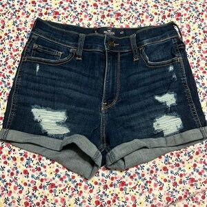 Lightly worn distressed jean shorts.